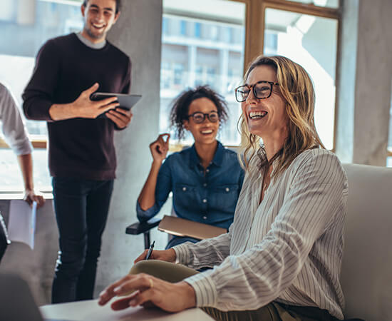 Laughing and smiling team members meeting in a conference room